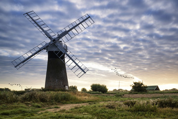 Fototapeta na wymiar Old pump windmill in English countryside landscape early morning