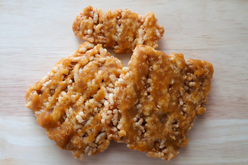 Local dessert in Thailand called Rice cracker or rice biscuits on wood background. Made from rices and jaggery