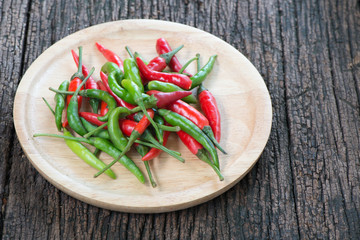 red and green thai chilli on wood plate