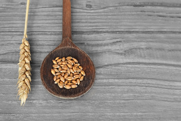 Wheat grains in wooden spoon
