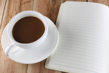 Obraz na płótnie Canvas White coffee cup and notebook.