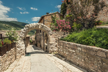 Fototapeta na wymiar Old rocky arch over the street in Spello, Umbria