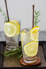 Lemonade with fresh lemon and rosemary in glass