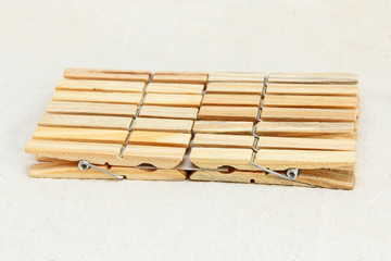 Several wooden clothespin on white fabric background.