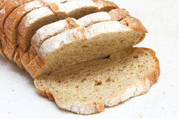 Fresh sliced bread taken closeup on white fabric.