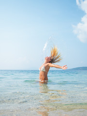 Naklejka premium blonde woman in the water waving hair