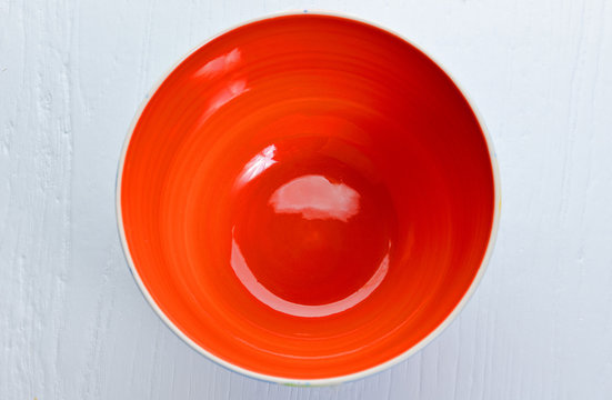 Top View Of The Red Bowl On Wooden Background.