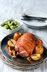 Roasted pork on a bed of vegetables and baked apples