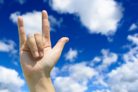 Love hand sign on blue sky