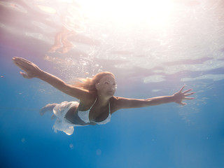 Obraz na płótnie Canvas beautiful woman in white dress underwater