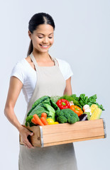 Healthy happy woman with crate of vegetables