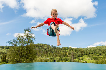 Young boy jumping on bouncing pillow