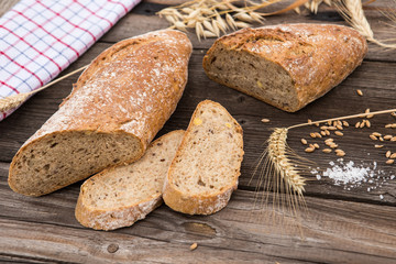 Rustic bread and wheat on an old vintage planked wood table.
