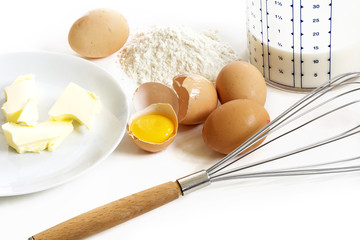 Baking ingredients for pancakes, butter, eggs, flour, milk and a