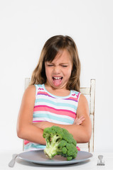 Girl sits at table unhappy with food