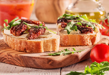 Sandwich with mozzarella, sun-dried tomatoes and arugula.