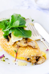 Omelette folded with mushrooms and fresh rocket