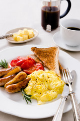 Scrambled egg breakfast with sausages, tomatoes and coffee