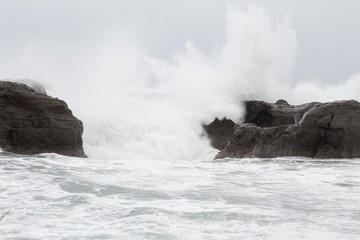 Stormy sea with waves crashing on rocks