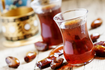 Two cups of black tea  in traditional Islamic cups with sweet da