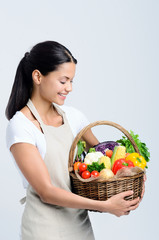 Attractive woman holding a basket of vegetables