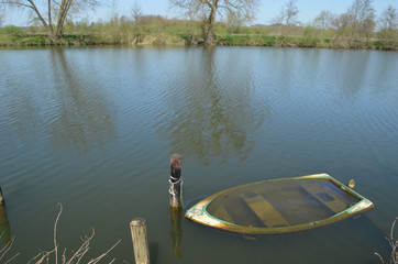 Sunken little wooden rowing boat in a lake © lembrechtsjonas