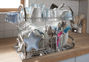 Dishes drying on a metal dish rack in a kitchen