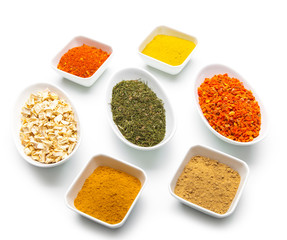Various spices and herbs on white background.