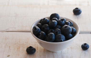 blueberries in a white bowl on wooden