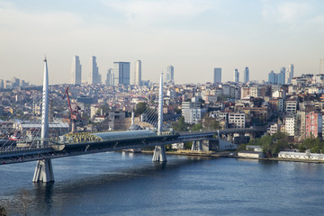 Naklejka premium Golden Horn Metro Bridge with old and modern side of Istanbul background view during the day time. Lots of building and sea view of Istanbul