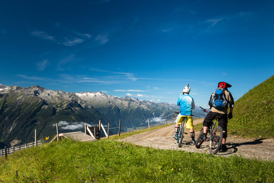 enduro bikers starting trail riding in austrian alps with mountain view on wildkogel