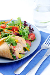 Vegetable burrito with chicken and cutlery