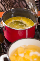 Soup with vegetables cooked in a pan, modern kitchen, selective focus