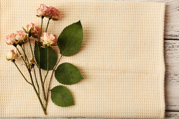 Beautiful dry flowers on napkin on wooden table close up