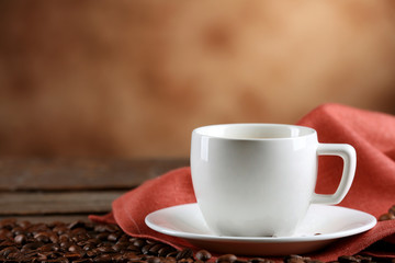 Cup of coffee and beans on blurred background