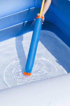 Kind mit Wasserpistole im Pool