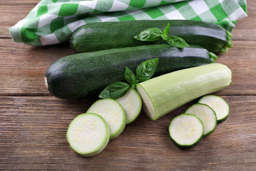 Fresh zucchini with squash and basil on wooden table close up