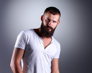 Fototapeta premium Portrait of handsome bearded man standing, isolated on grey