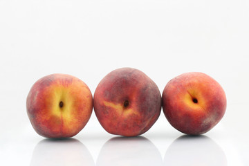 three ripe peach on a white background