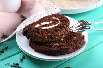 Delicious chocolate roll on wooden table, closeup