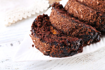 Delicious chocolate roll in white saucer, closeup