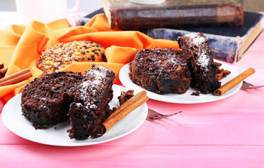 Delicious chocolate roll on wooden table with orange napkin and books ,closeup