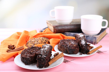 Delicious chocolate roll on wooden table with orange napkin and books ,closeup