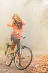 Obraz na płótnie Canvas Happy active woman riding bike in autumn park.