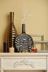 Modern vases with decor on fireplace in room