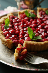 Piece of tart with raspberries on tray, close-up