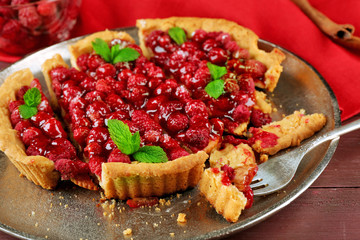 Tart with raspberries on tray, on wooden background
