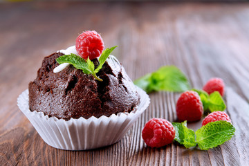 Delicious chocolate cupcake with berries on wooden table close up
