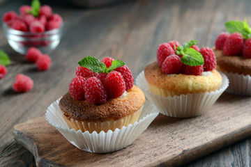 Delicious cupcakes with berries and fresh mint on wooden table close up