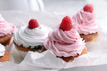 Delicious cupcakes with berries on table close up